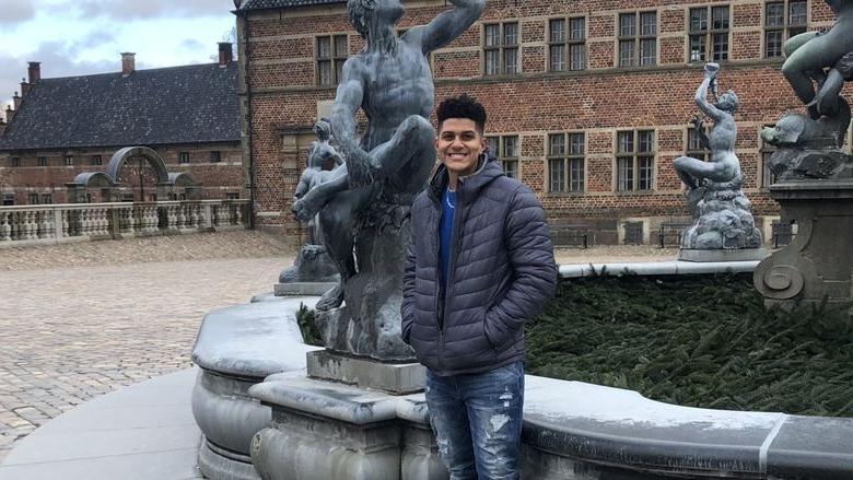 Jermain Jones stands in courtyard at castle in Denmark during study abroad trip over spring break